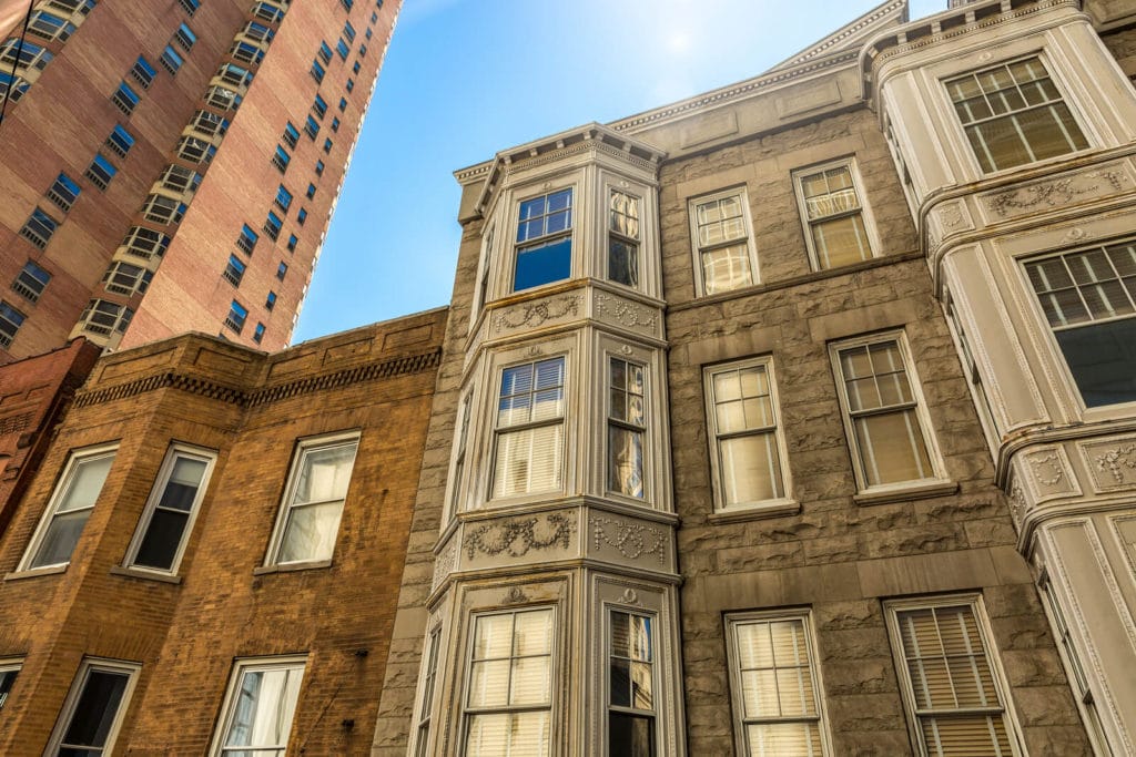 looking upward at multi story chicago style homes from the street.