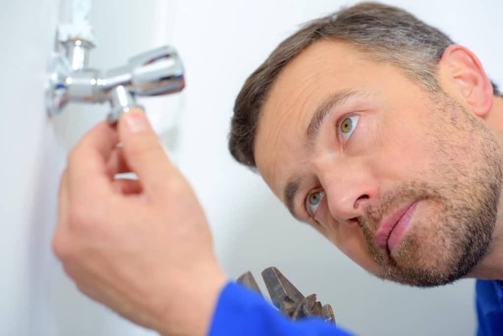 home inspector looking at a faucet